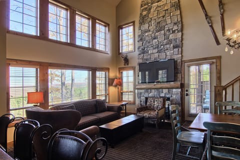Cozy living room with beautiful floor to ceiling windows and cus - Cozy living room with beautiful floor to ceiling windows and custom stone fireplace