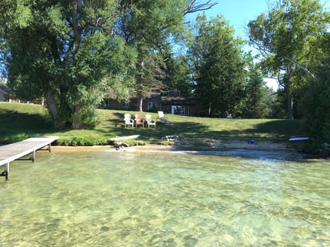 Midday in the summer looking from the lake to the house. The water is so clear.
