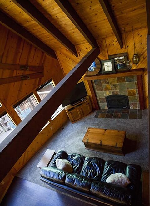 View of warm and cozy living area with high vaulted ceiling and gas fireplace.