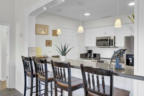 - Start your mornings at the spacious breakfast bar with seating for four - Pendant lighting and a wide archway add style and flow to the open layout - Fully equipped kitchen behind the bar makes meals and snacks a breeze