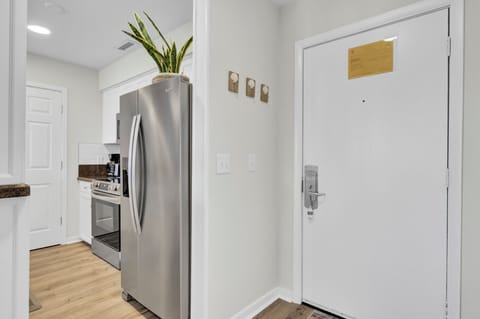- Step into a bright, welcoming space with immediate access to kitchen essentials - Stainless steel fridge and sleek floors lead the way to a seamless stay - Handy wall hooks and a clean layout make unpacking and settling in effortless