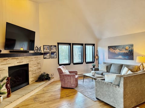 Living room with vaulted ceiling, fire place, 65" TV and beautiful views.