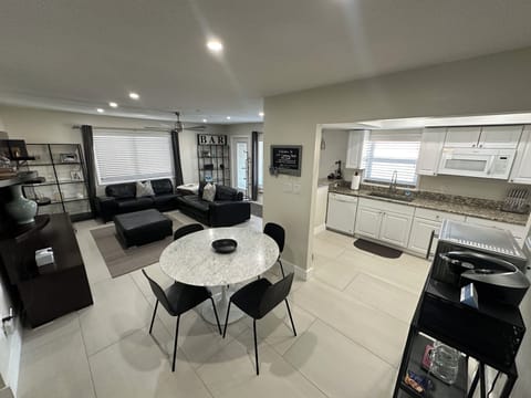 Open living area with kitchen table and counter with barstools 

