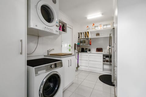 A well stocked butlers pantry and laundry for your convenience.