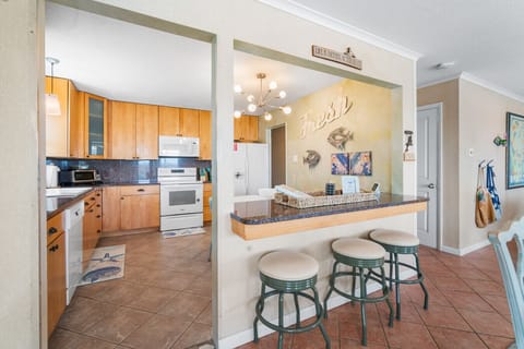 Fully equipped kitchen with modern appliances and convenient breakfast counter.