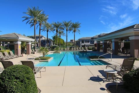 Heated community pool with covered area and grill for outdoor eating