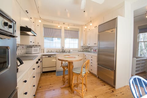 Wine tasting island or picnic planning in bright double window kitchen