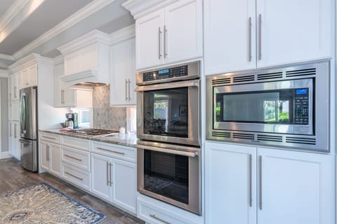 Kitchen features high end appliances including double oven and gas cooktop.