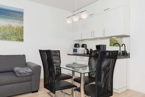 Spacious and bright living room with kitchenette, dining area and elegant double sofa bed.