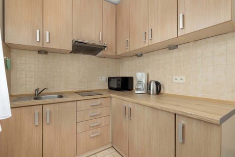 Kitchenette with bright furniture microwave and electric kettle.