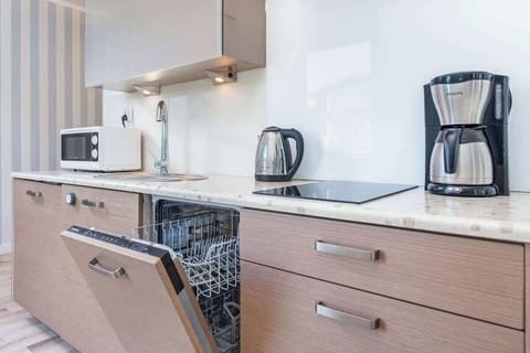 Practical kitchenette with a microwave, coffee machine, electric kettle, dishwasher and toaster.