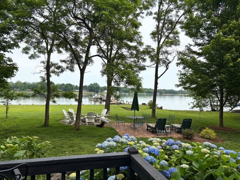 View from deck of brick patio, fire pit area, & pier w/ separate floating dock.