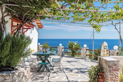 Outdoor dining with open views over the Aegean Sea.