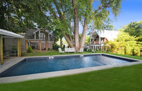 Pool with main house and barn/cottage in background.