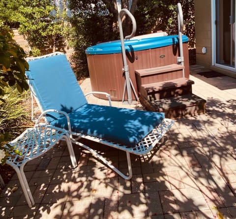 Hot tub and lounge chair in back yard.