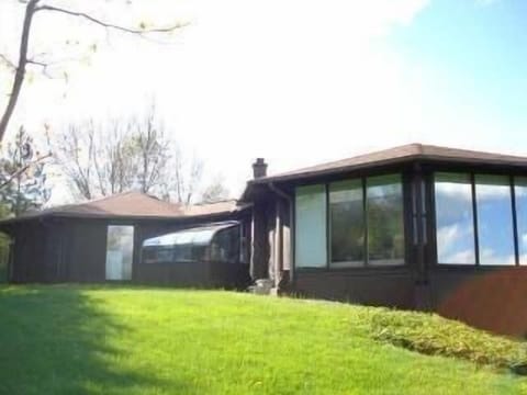 Beautiful floor to ceiling windows look out onto lawn and forest