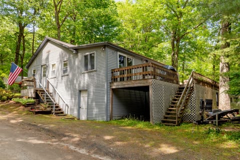 Cabin with expansive deck nestled among lush woods.