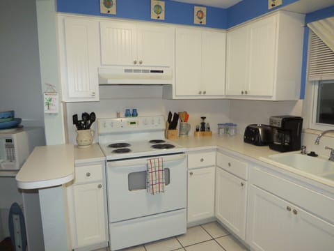 Fully equipped kitchen with stove, oven, microwave, toaster, and coffee maker
