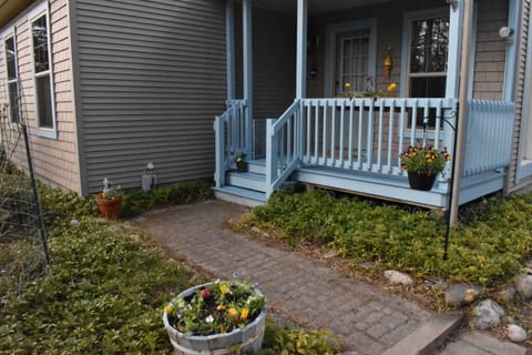 Secure covered front porch provides convenient entryway and shaded seating.
