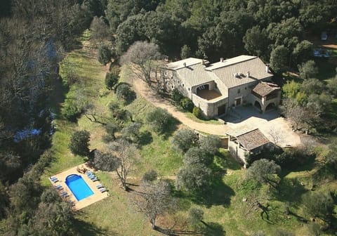 A bird's eye view of the villa, with outdoor dining areas & pool & gardens