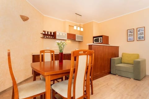 A kitchen with wooden cabinetry and an open design that connects with the dining area. The setup is spacious, with ample countertop space.