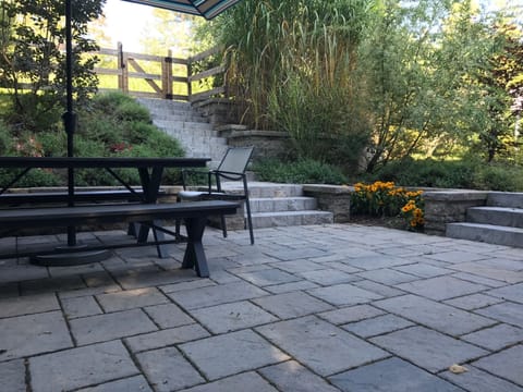 back deck leading to pool, has gas grill, table and umbrella