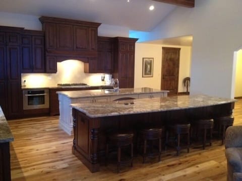 Kitchen with two island.  5 bar stools, lounge area, wood burning fireplace.
