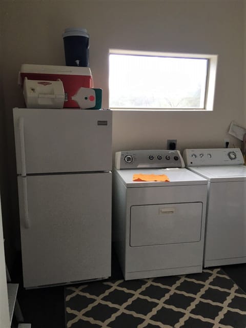 Laundry room with extra fridge.