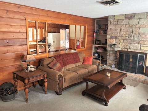Living Room with wood burning fireplace.  Open to kitchen and view to Lake.