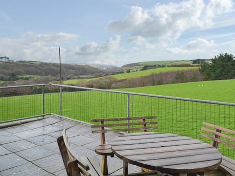 Paved patio with table and chairs to admire the landscape | Porth View - Higher Lanvean Farm, St Mawgan, near Newquay