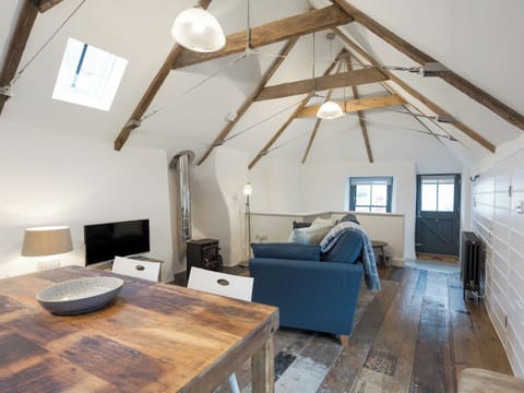 Open plan living space with original distressed solid wooden floors, high apex ceiling and beams | 9 Chapel Street, Mousehole, near Penzance