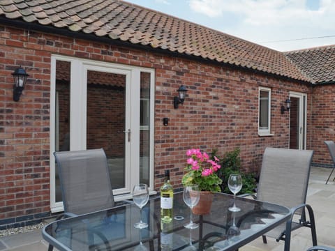 Stylish contemporary table and chairs in a courtyard setting | The Old Dairy - Dunstall Lodge Barns, Sutton-on-Trent
