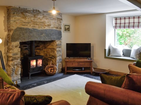 Cosy living room with wood burner and slate floor | Maybill Cottage, Cwm Penmachno, near Betws-y-Coed