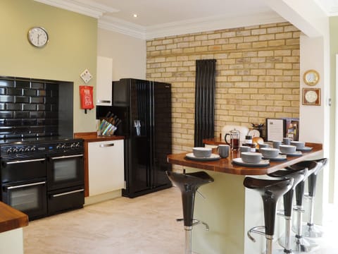 The feature brick wall, American style fridge freezer and range cooker gives the kitchen a professional fell | Island View, Amble