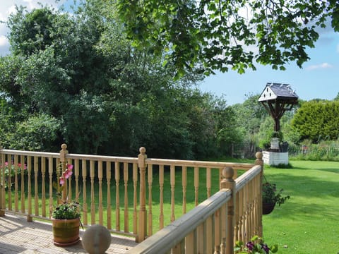 Decking with view over garden | Hunter’s Cottage - Llwyn Ffynnon, Y Ffôr, near Pwllheli