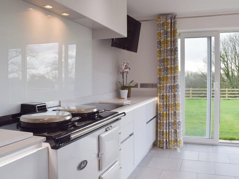 An Aga and sliding doors to the garden give the kitchen area a classical feel | Ivy Bush Cottage, New Moat, near Narberth