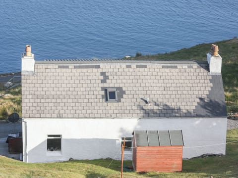 Traditional Highland croft perched on the shore of Loch an Tairbeart | Tigh Mairi, Carragrich, near Tarbert, Isle of Harris