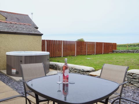 Enclosed lawned garden with patio, garden furniture and private hot tub. | Yr Hen Feudy - Bronallt Barns, Llanynghenedl, near Holyhead