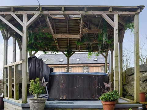 Relaxing sitting-out-area and covered hot tub | Kris Kin - Ymwlch Barns, Ymwlch, near Porthmadog
