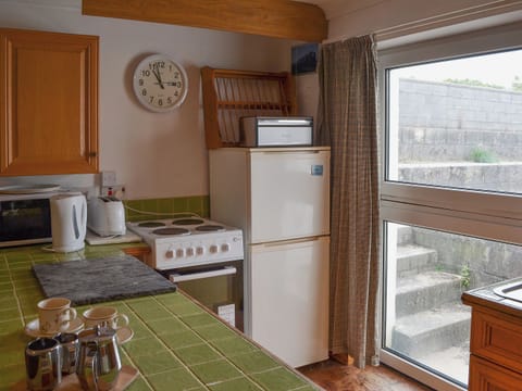 Modest kitchen with direct access to decked area | Glan-Mor, Pwllheli