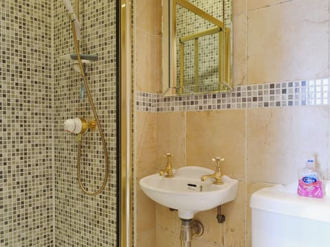 The luxurious en suite shower room features a full height walk in shower and washbasin | Oak Lea, Keswick