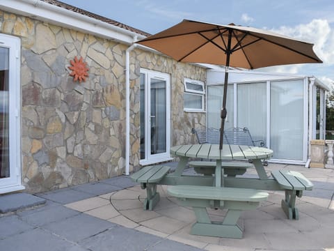 Sheltered spot on the patio for alfresco dining | Sunset Cottage - St Anne&rsquo;s Cottages, Chickerell, near Weymouth