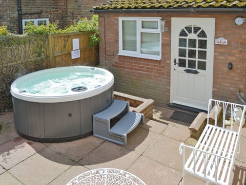 Hot tub and sitting out area within front courtyard | Sweet Pea Cottage, Holt