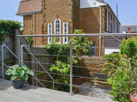 Wooden balcomy overlooking the courtyard style garden | The Mistress’ House, Hunstanton