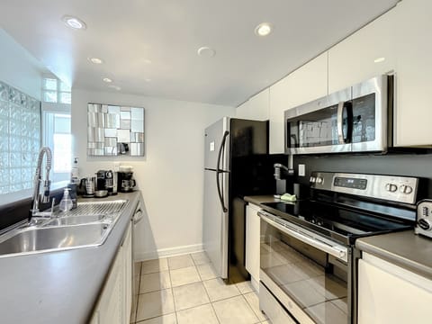 Modern Kitchen Haven - Discover the full-size kitchen with a bar, equipped with Nespresso and Keurig coffee makers, toaster, Soda Stream for sparkling waters, and Vitamix for the perfect health drinks.
