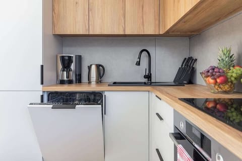 A bright kitchen-dining space with a modern wooden dining table set with turquoise plates and glasses, perfect for a family meal.