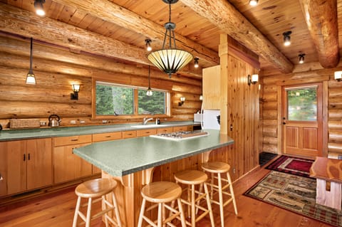 Kitchen with a lot of counter space and plenty of dishes and cooking utensils.