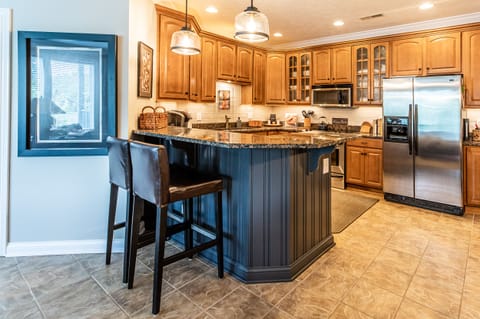 Tiled backsplash, under-counter lighting, bar seating with granite countertops.