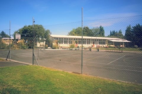 Looking across the tennis court to the school. The apartment is behind the tall birch tree