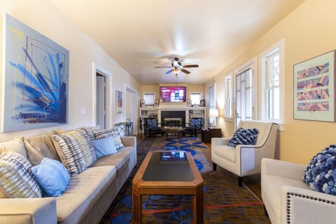 Livingroom with dual seating areas, 65" smart tv and queen sleeper sofa.